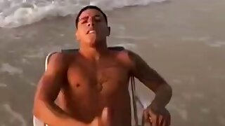 Bator strokes his dong at the beach and sperms all over his chest